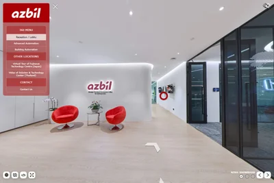 Azbil Singapore reception lobby with red lounge chairs, branded wall sign, and three digital display screens